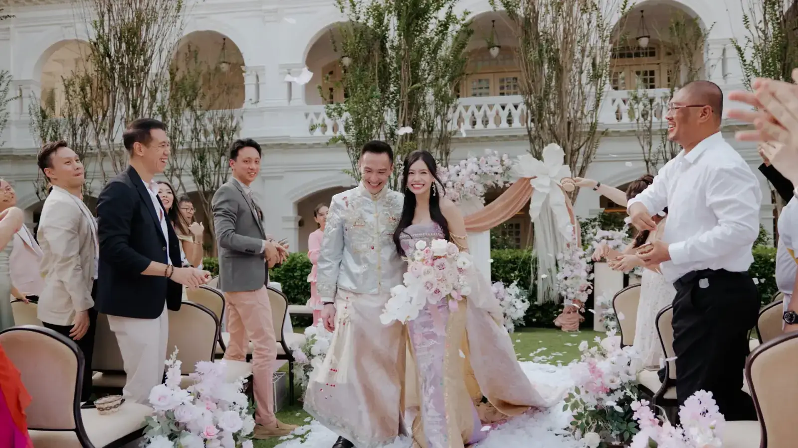 Bride and groom marching out after the Raffles Hotel wedding ceremony