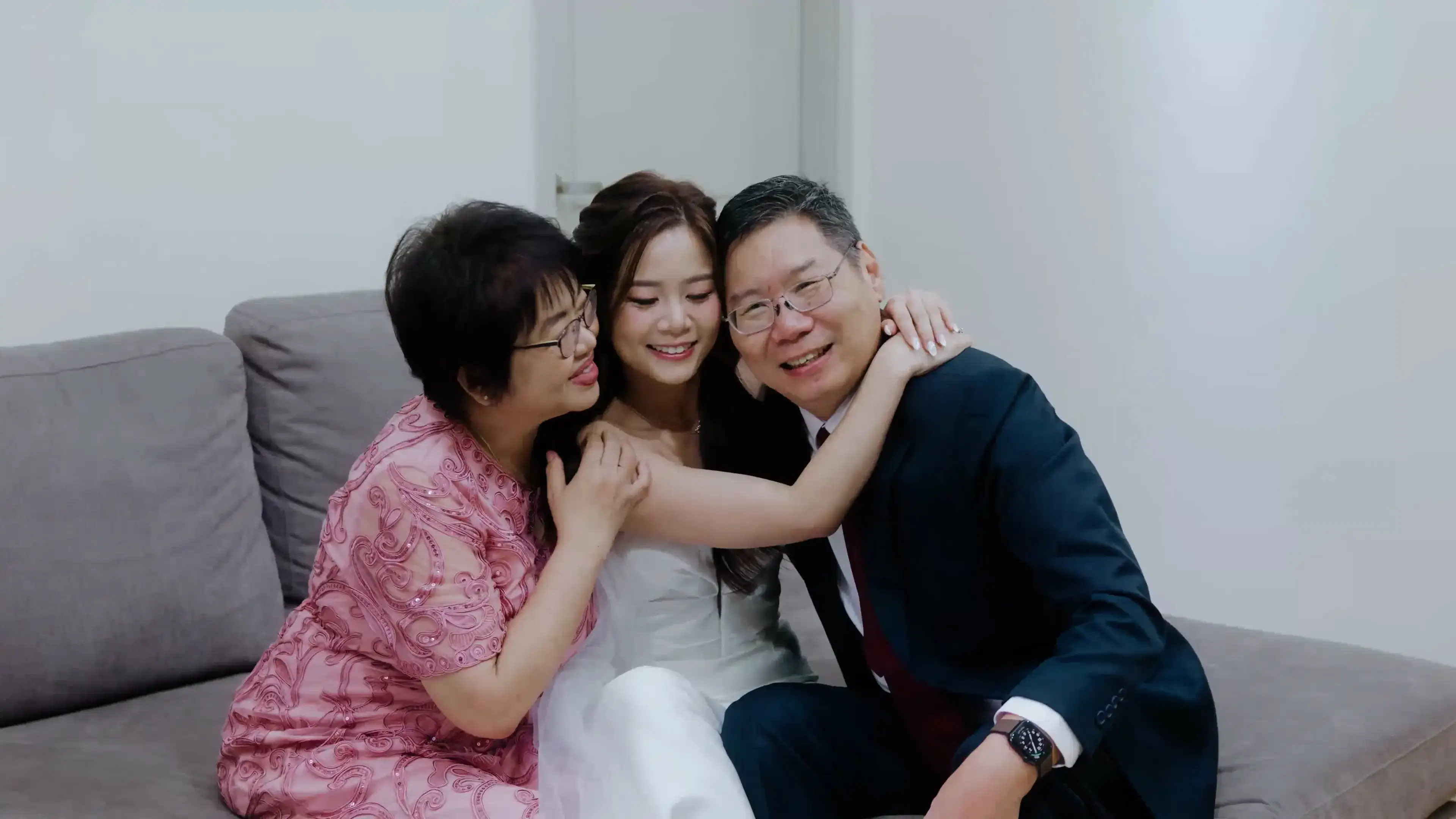 Bride hugging her parents at home
