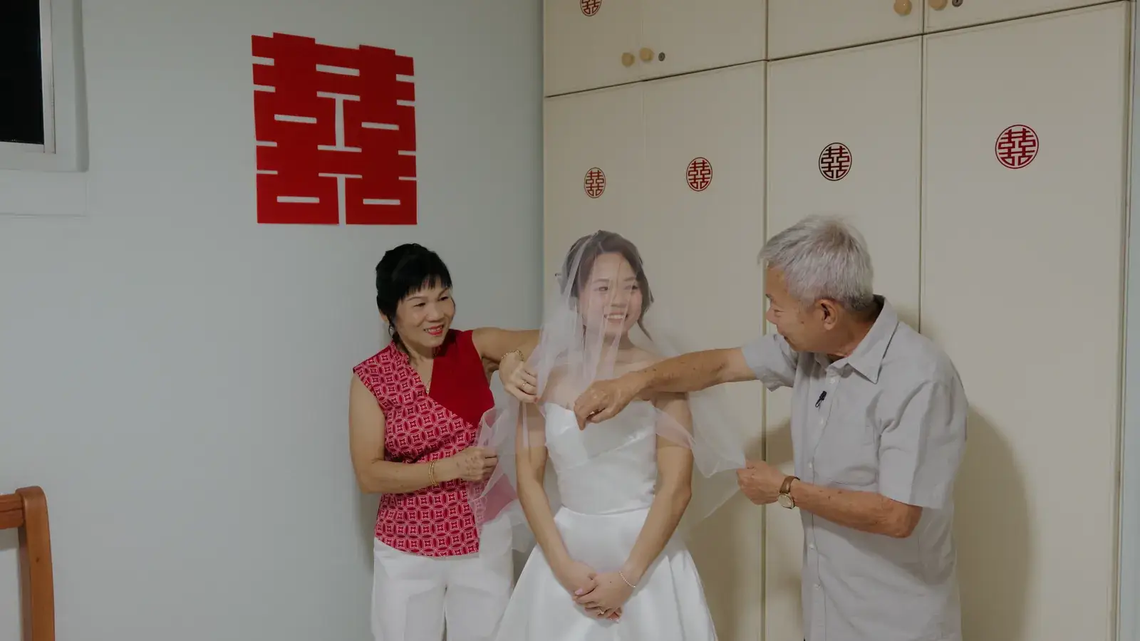 Bride veiling with her parents during the family blessing at home