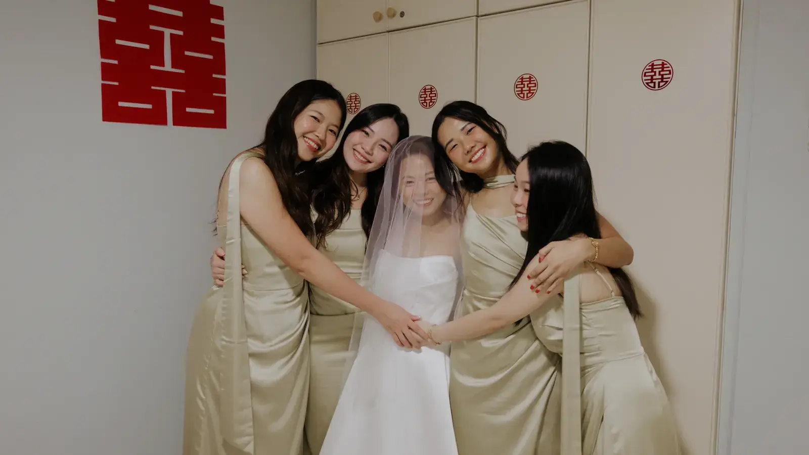 Bride hugging her bridesmaids during the wedding morning shoot