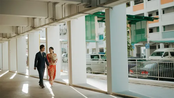 Gee Chuan and Min Xian walking hand in hand in traditional wedding attire