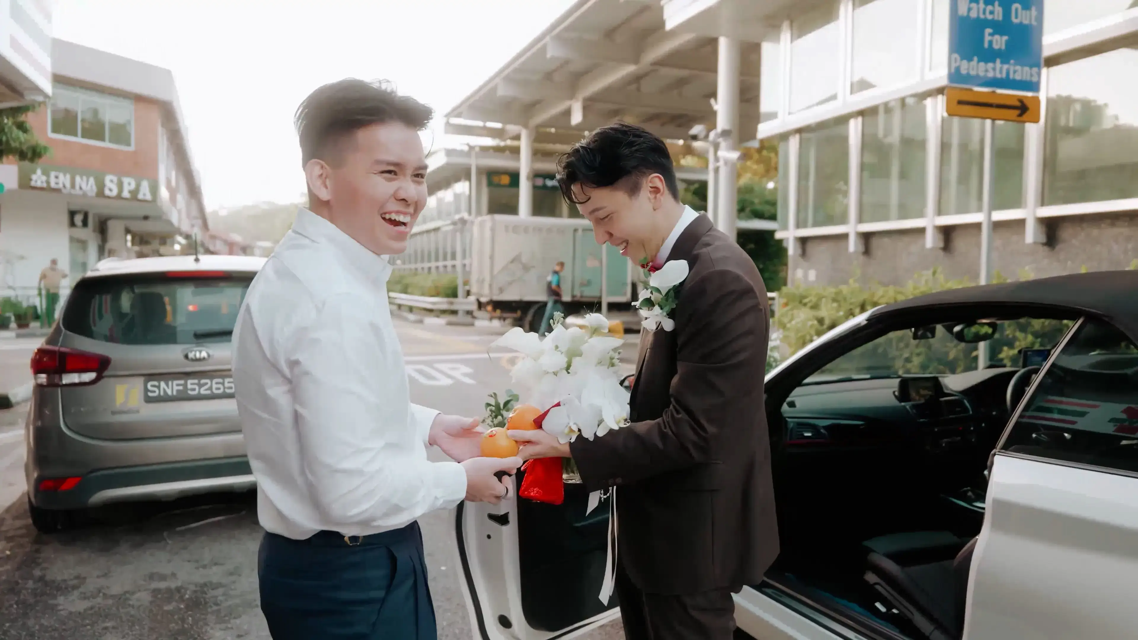 Nephew opening the wedding car door for the groom